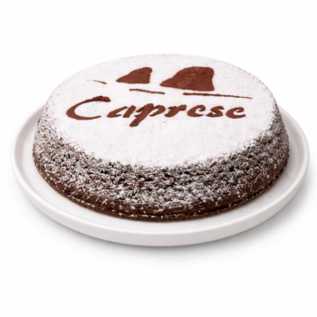 Torta Caprese artigianale al cioccolato e mandorle su piatto bianco